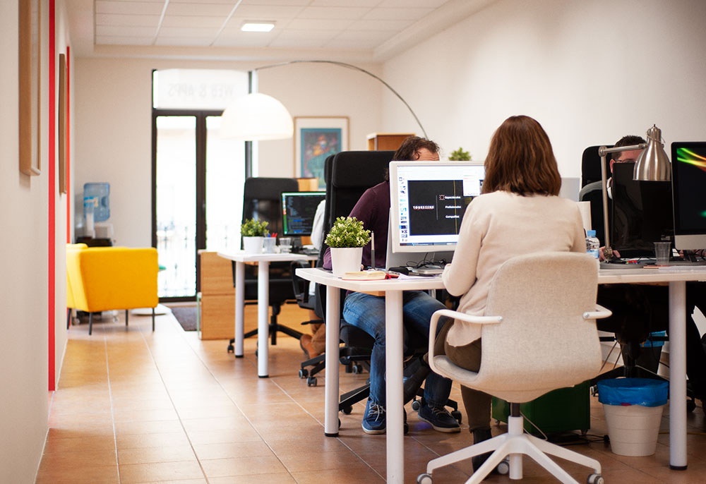 Miembros de Eclectick Studio discutiendo las estrategias de desarrollo de un proyecto alrededor de una mesa.